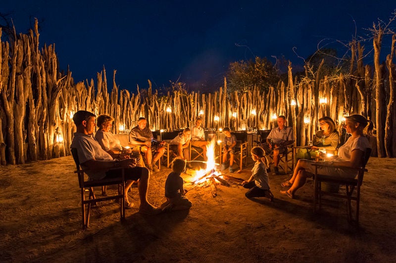 Elevated luxury safari tent overlooking pristine Linyanti wetlands, with wooden deck, canvas walls and elegant outdoor seating