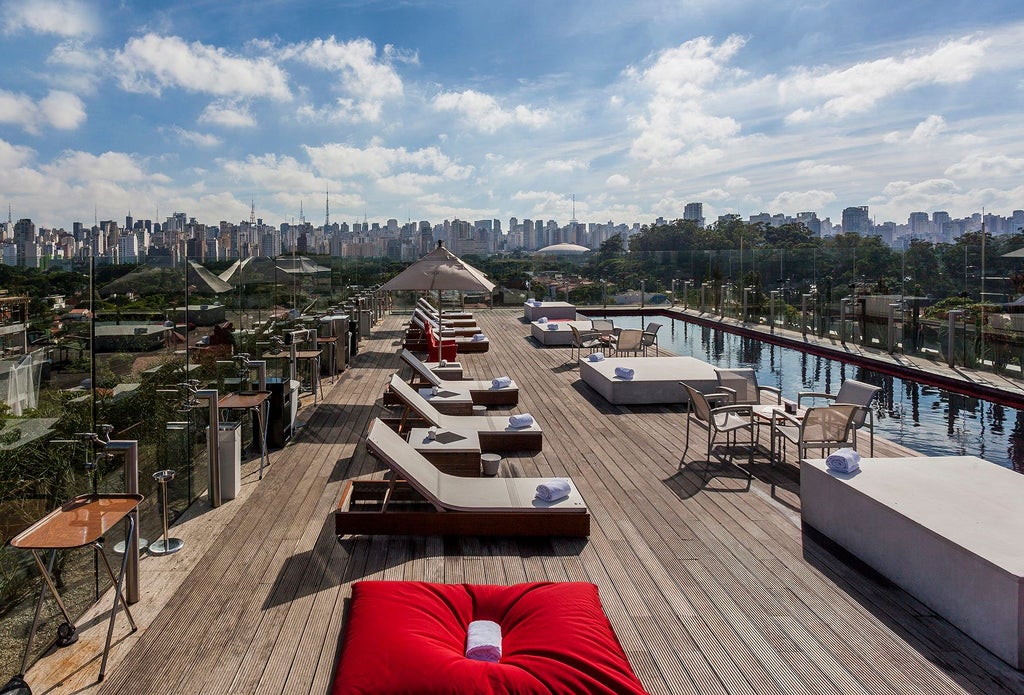 Modern luxury hotel with striking red-orange facade, unique architectural design featuring curved lines and geometric shapes, situated in an urban Brazilian setting with vibrant metropolitan backdrop