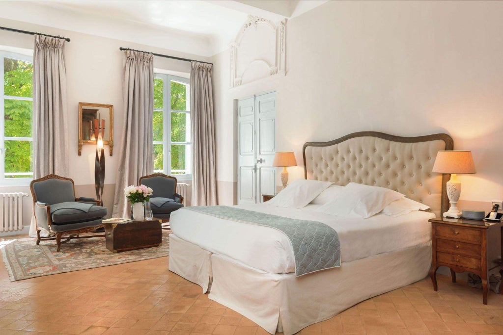 Luxurious hotel bedroom with elegant French decor, soft neutral tones, antique furnishings, and large windows overlooking a serene garden landscape