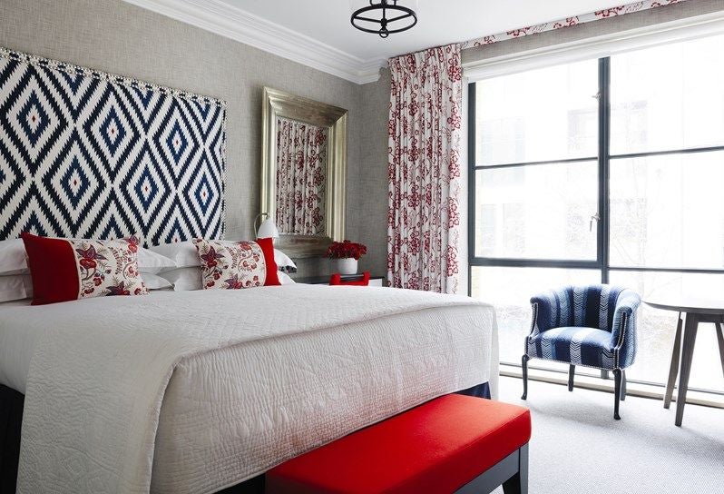 Elegant superior room at Ham Yard Hotel with contemporary design, plush white bedding, modern artwork, and warm wood accents in a stylish UK setting