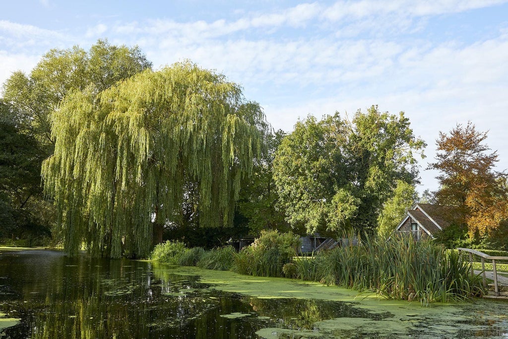 Rustic stone mill hotel nestled by a tranquil river, featuring elegant wood-paneled interiors and picturesque countryside views in scenic United Kingdom landscape