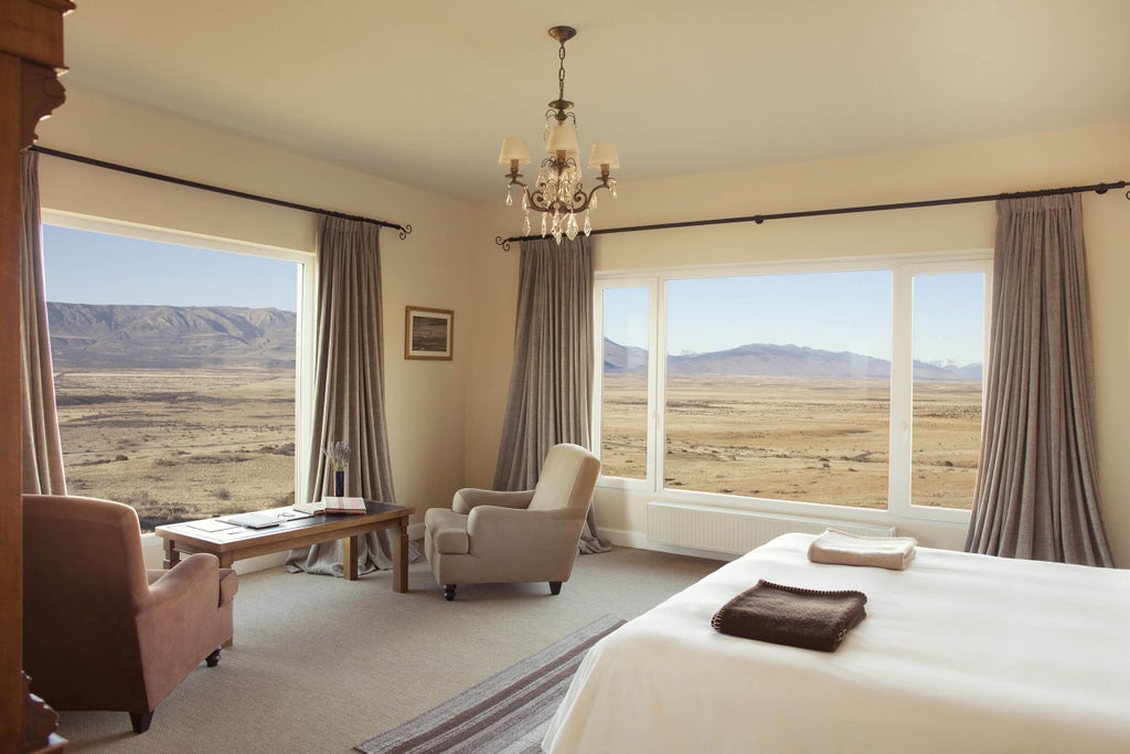 A luxurious lodge nestled in the Patagonian steppe, with modern glass windows reflecting mountain views and dramatic open grasslands