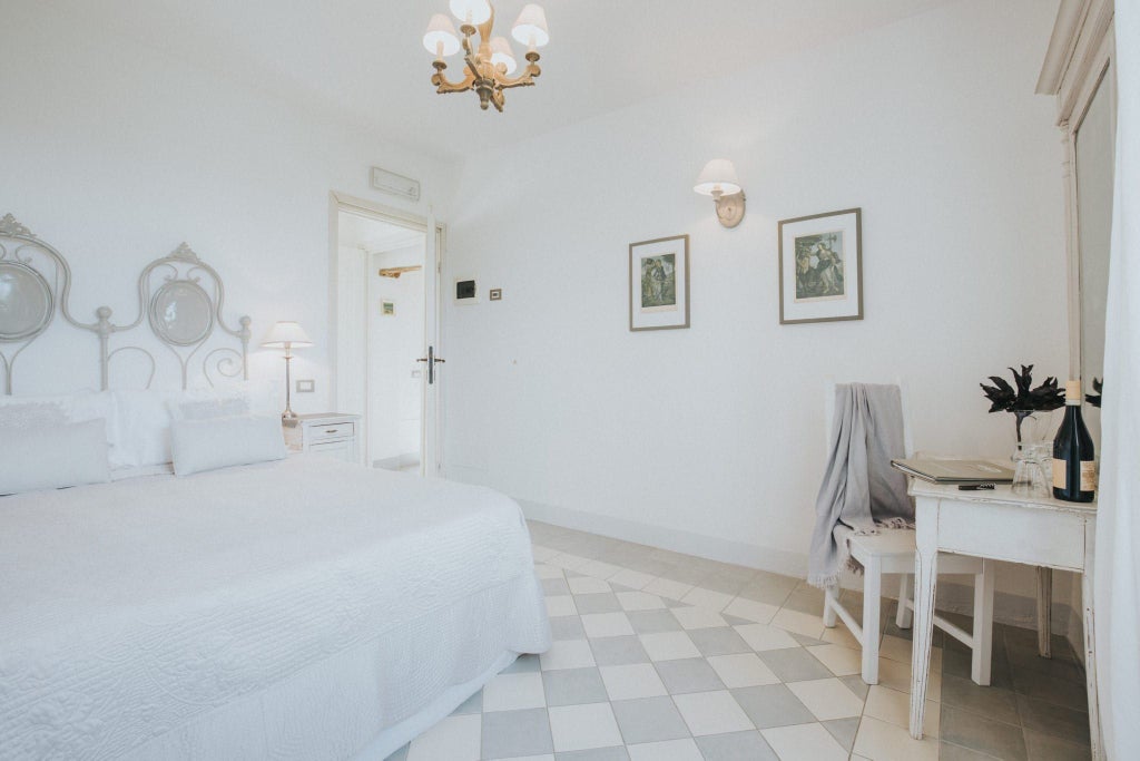 Elegant blue-toned luxury hotel room at La Villa with plush white bedding, contemporary decor, and soft Mediterranean natural lighting near Italian coastline