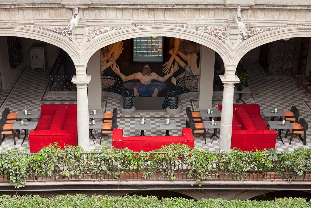 Luxurious colonial-style hotel lobby with high ceilings, elegant stone archways, and traditional Mexican decor in warm terracotta and ochre tones