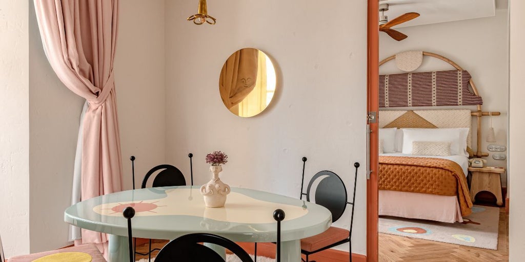 Luxurious Dalt Vila Suite with white minimalist design, wooden accents, and panoramic views of Ibiza's historic Old Town architecture