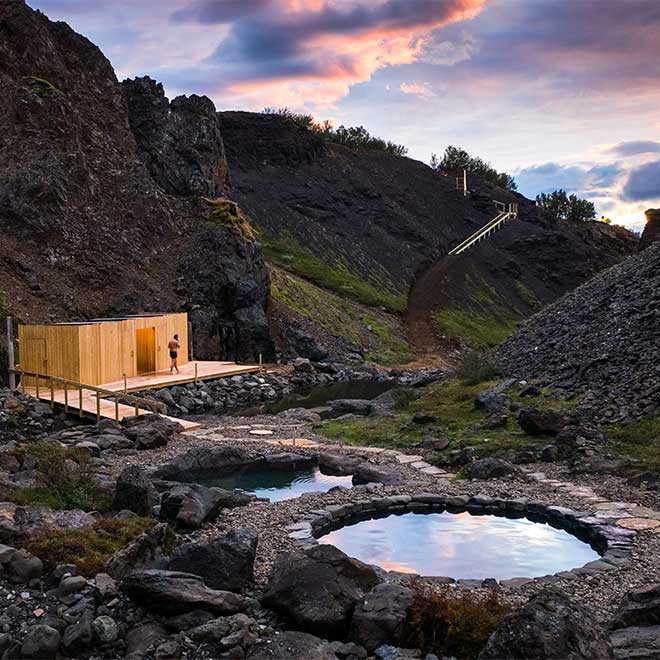 Modern Nordic hotel nestled in snowy Icelandic wilderness, featuring minimalist architecture, floor-to-ceiling windows, and mountain views