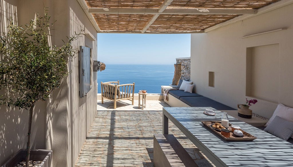 Minimalist white luxury hotel room with panoramic Aegean Sea view, sleek design, elegant white bedding, and modern minimalist furnishings in Sifnos, Greece