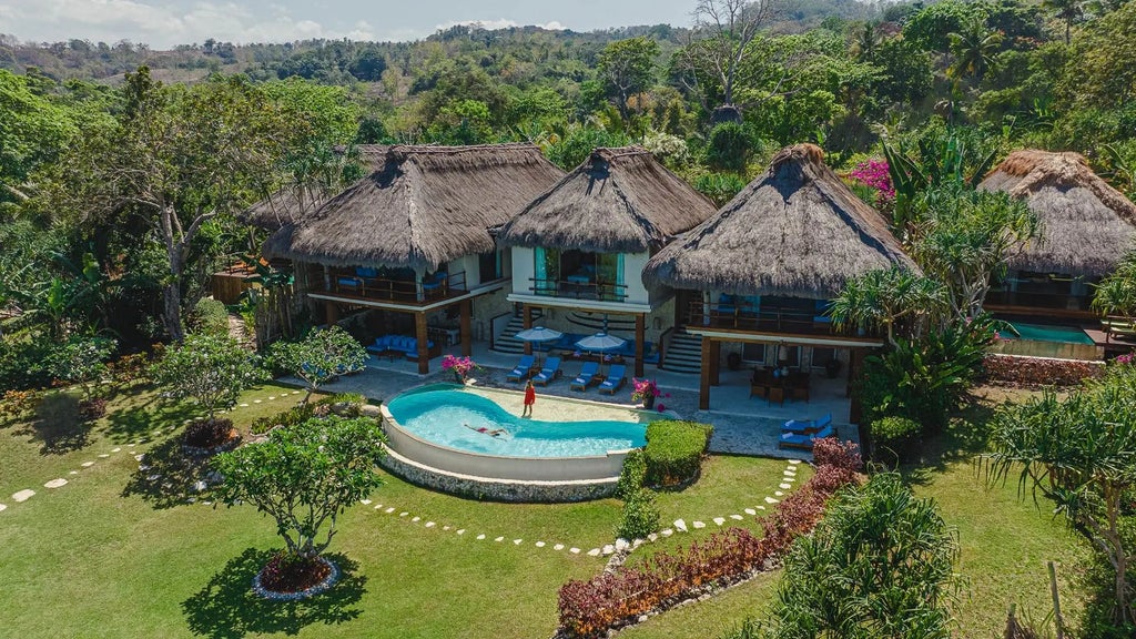 Luxurious open-air bedroom in NIHI Sumba Lantoro Estate, featuring panoramic ocean views, traditional Indonesian design, and a private infinity pool at sunset