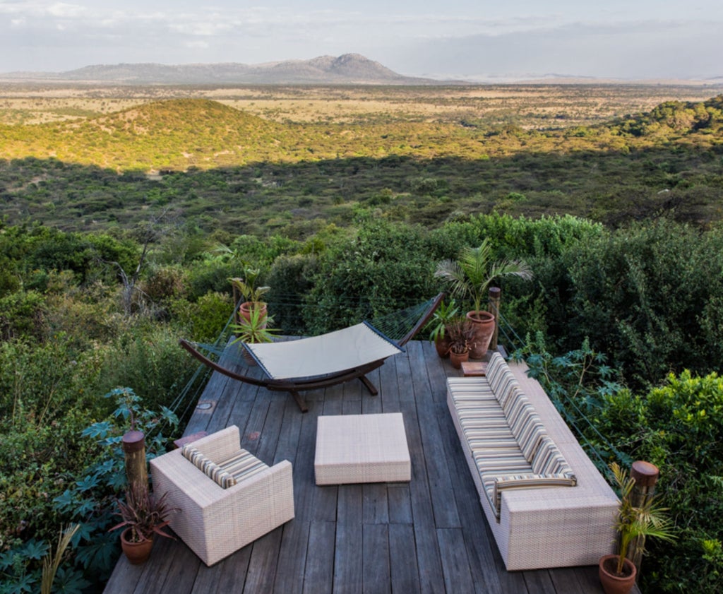 Luxurious safari tent at Cottar's Camp with white canvas walls, elegant colonial furniture, and sweeping views of Kenyan savanna