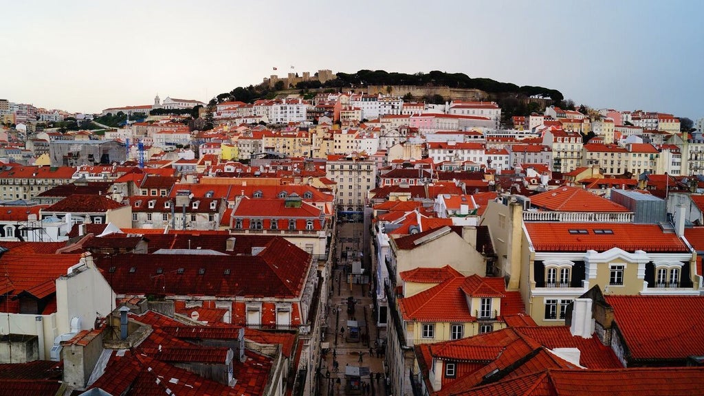 Elegant boutique hotel facade in Porto's historic Baixa district, featuring traditional Portuguese architecture with wrought-iron balconies and warm limestone exterior