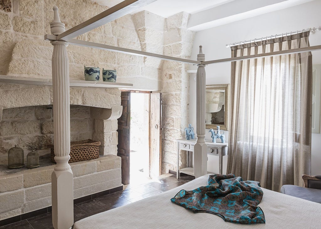 Elegant stone-walled Italian hotel room with arched loggia window, antique wooden furniture, and soft natural light illuminating rustic Mediterranean decor