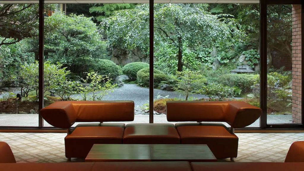 Modern glass-fronted Hyatt Regency hotel in Japan with sleek architecture, illuminated entrance and landscaped gardens at dusk