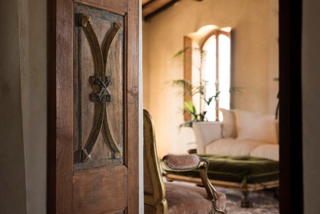 Elegant stone-walled suite with rustic wooden beams, antique furnishings, and a luxurious canopy bed overlooking Tuscan countryside at Castello di Vicarello