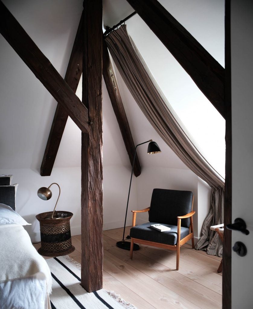 Rustic wooden interior of Transylvanian caretaker's house, featuring handcrafted furniture, warm earth tones, and elegant traditional Romanian textiles