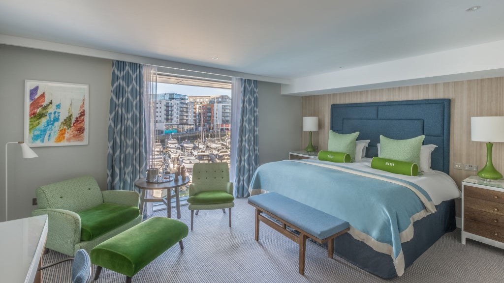 Spacious accessible hotel room with modern decor, large window overlooking maritime scenery, adaptive furnishings, and welcoming neutral color palette in Southampton.