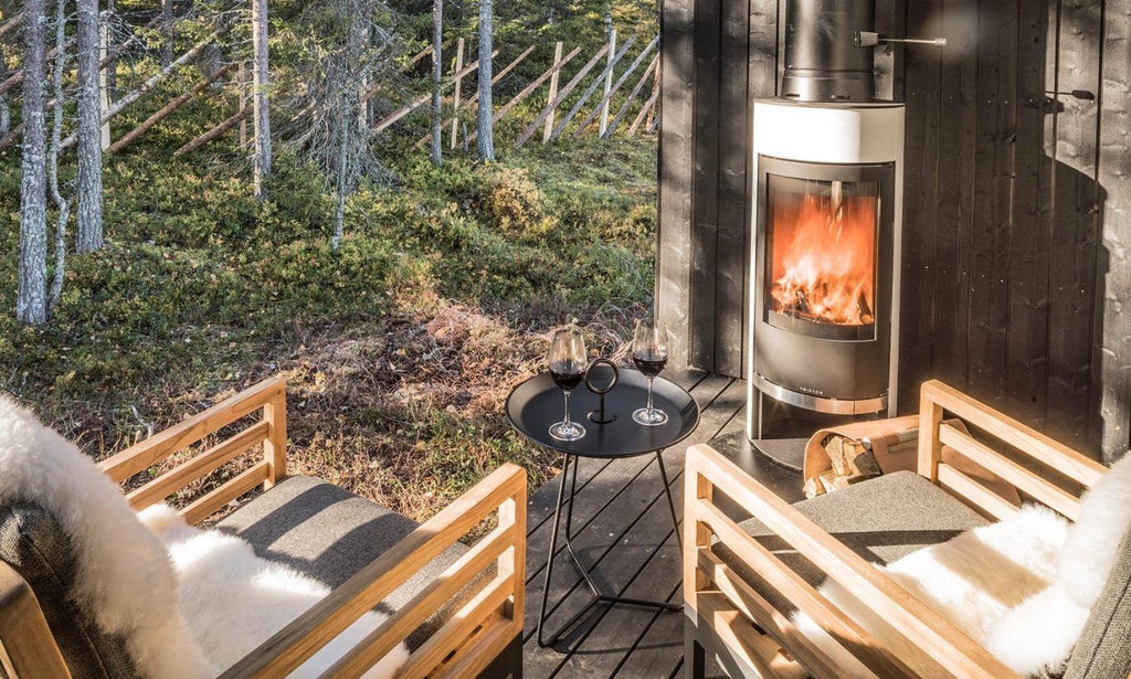 Modern Scandinavian luxury suite with panoramic window overlooking snowy forest, featuring minimalist wooden design and cozy Arctic ambiance