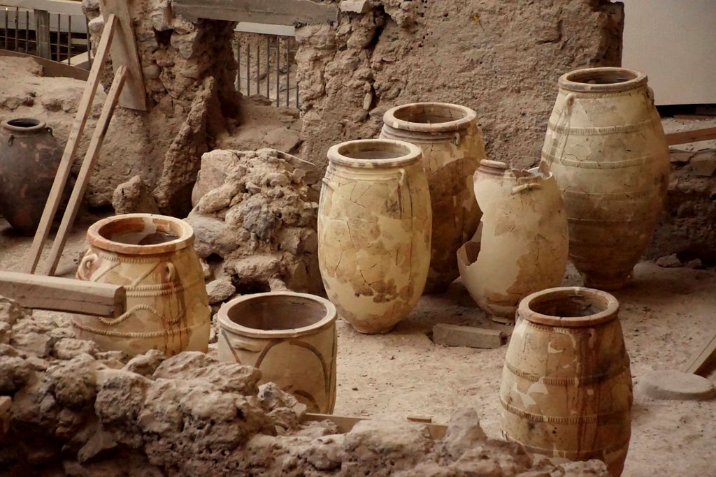 Whitewashed Santorini villages perched on volcanic cliffs, with blue-domed churches and elegant travelers exploring ancient Akrotiri archaeological site at golden hour