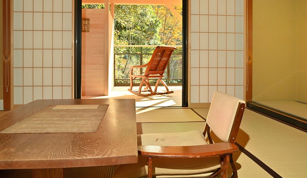 Luxurious Japanese minimalist suite with tatami floors, elegant wooden furnishings, expansive mountain view window, and traditional architectural elements in soft neutral tones