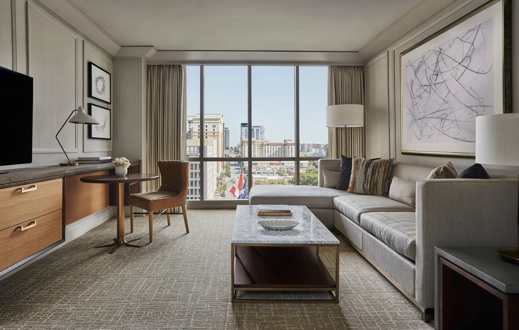 Luxury downtown hotel with modern glass facade overlooking Lady Bird Lake, featuring manicured gardens and elegant outdoor terrace