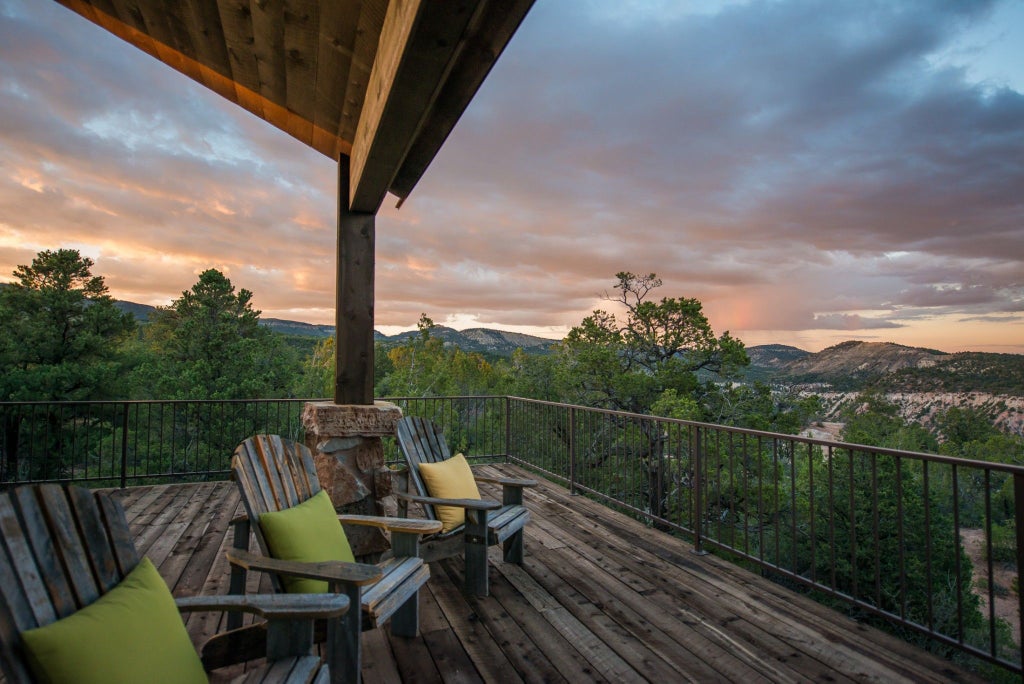 Rustic wooden lodge bedroom at Mountain Ranch with plush king bed, large window overlooking pine forest, warm neutral decor in scenic mountain retreat