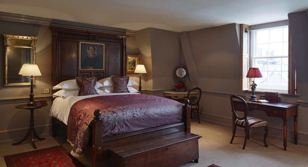 Opulent Georgian-style hotel room with plush velvet furnishings, ornate four-poster bed, and rich dark wood paneling in luxurious neutral tones