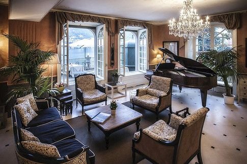 Elegant lakeside hotel nestled in lush Italian gardens, with Lake Como's sparkling waters and historic architecture framing a luxurious, romantic scenset retreat.