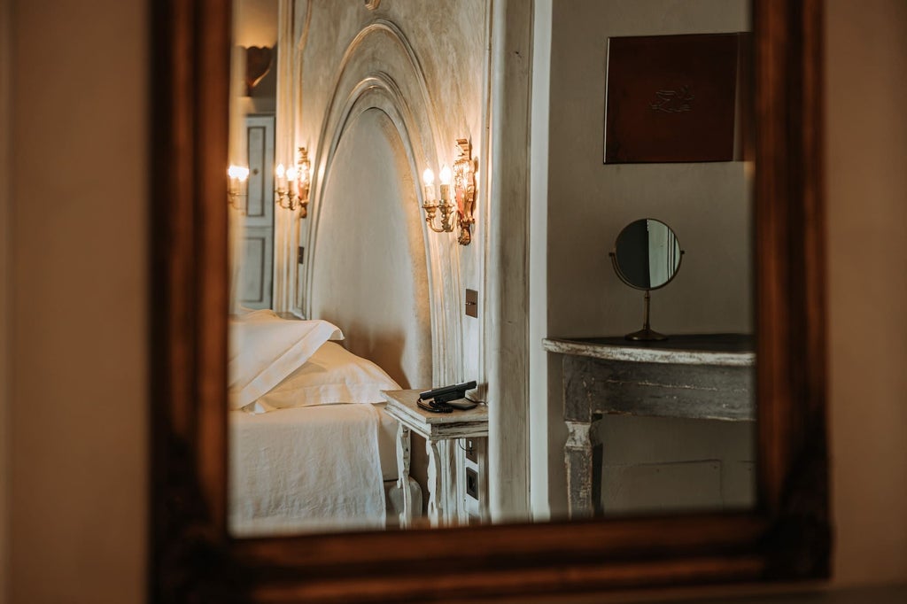 Luxurious Paragon Suite with elegant white bedding, marble bathroom, and panoramic Italian landscape view through expansive floor-to-ceiling windows