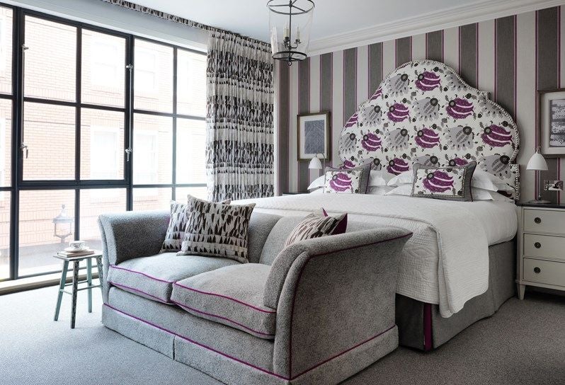 Luxurious deluxe hotel room at Ham Yard Hotel with modern design, plush king bed, stylish seating area, and warm neutral color palette in a UK setting.