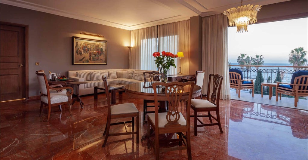 Luxurious one-bedroom suite with modern decor, plush king bed, elegant marble bathroom, and panoramic coastal views of Cyprus from private balcony