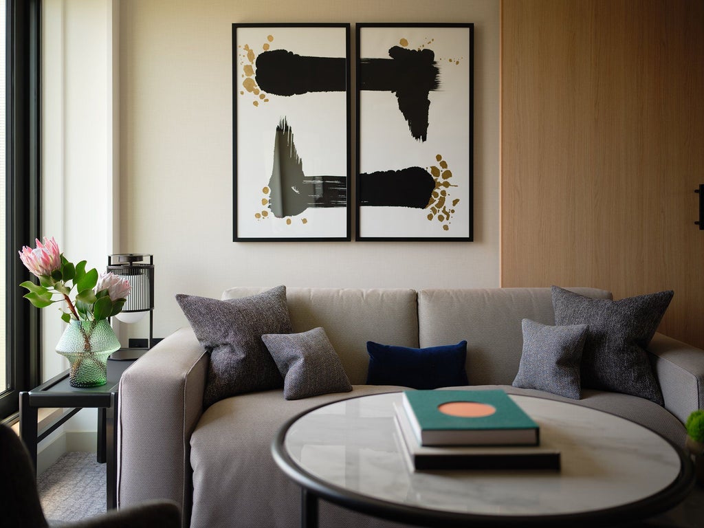 Minimalist zen suite with neutral tones, featuring a king bed, sleek furniture, and floor-to-ceiling windows overlooking London's cityscape at Nobu Hotel.