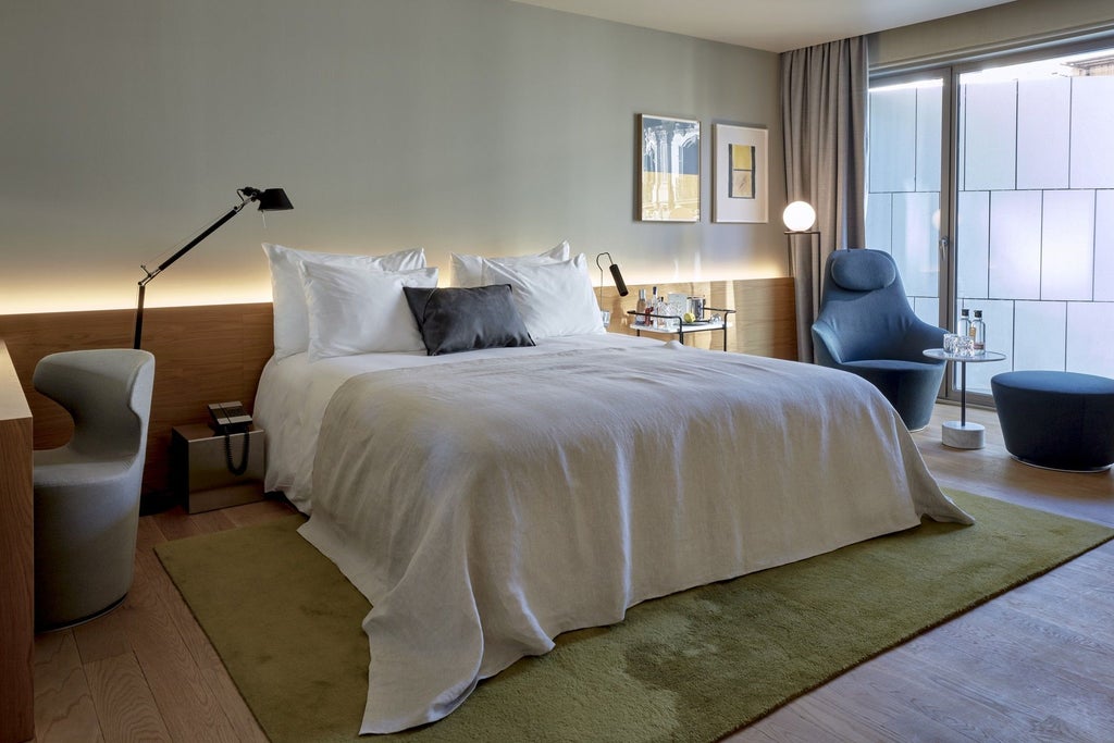 Elegant modern hotel room with minimalist design, floor-to-ceiling windows, sleek furniture, and warm neutral tones at luxury scenset hotel in Spain