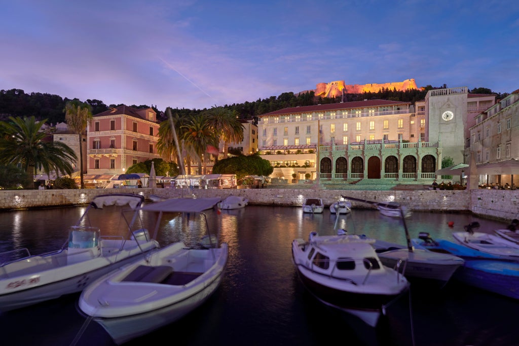 Elegant stone facade of Palace Elizabeth hotel overlooking Hvar harbor, with ornate balconies and classic Mediterranean architecture