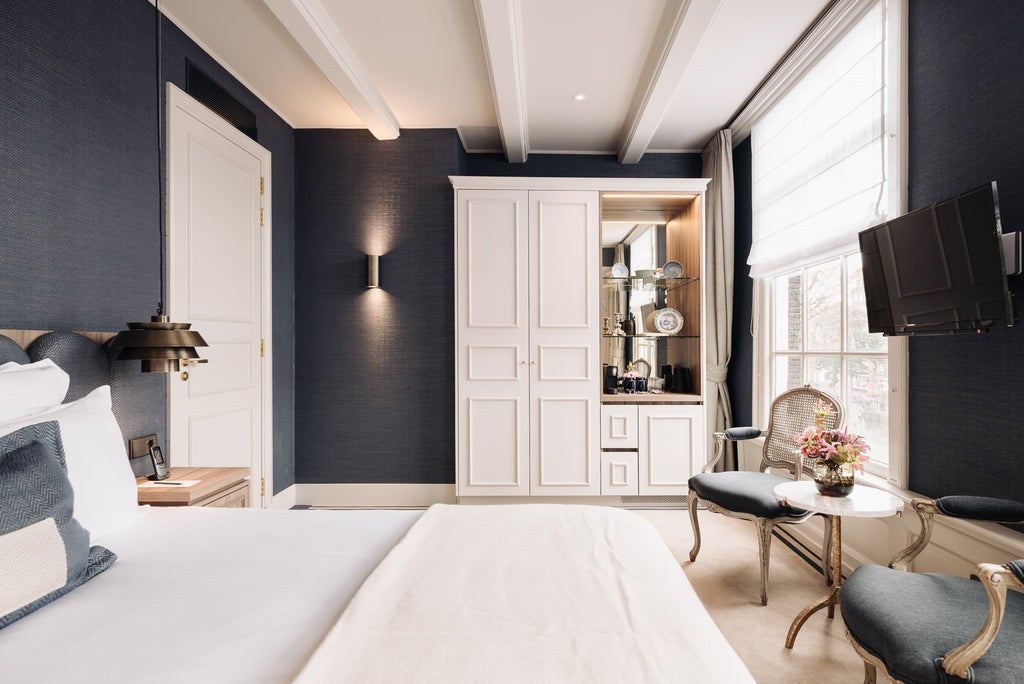 Elegant spacious hotel room with plush king bed, contemporary Dutch-inspired decor, large windows, warm neutral tones, and luxurious amenities in a boutique Netherlands accommodation