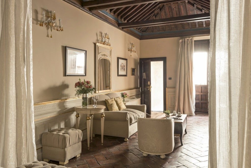 Elegant Spanish colonial courtyard with ornate marble columns, wrought-iron balconies and crystal chandelier at Casa 1800 Granada hotel