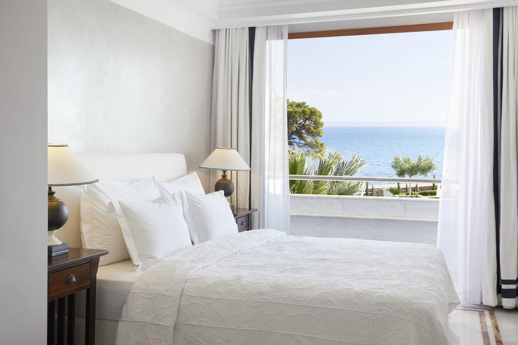 Spacious two-bedroom luxury suite at Danai Beach Resort with panoramic sea view, elegant wooden furnishings, and private balcony overlooking Aegean coastline in Greece