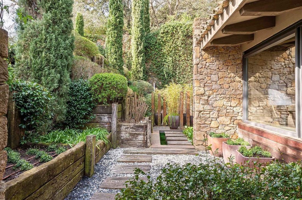 Elegant 5-star Catalan farmhouse hotel with stone facade, manicured gardens, terracotta roof tiles and panoramic countryside views