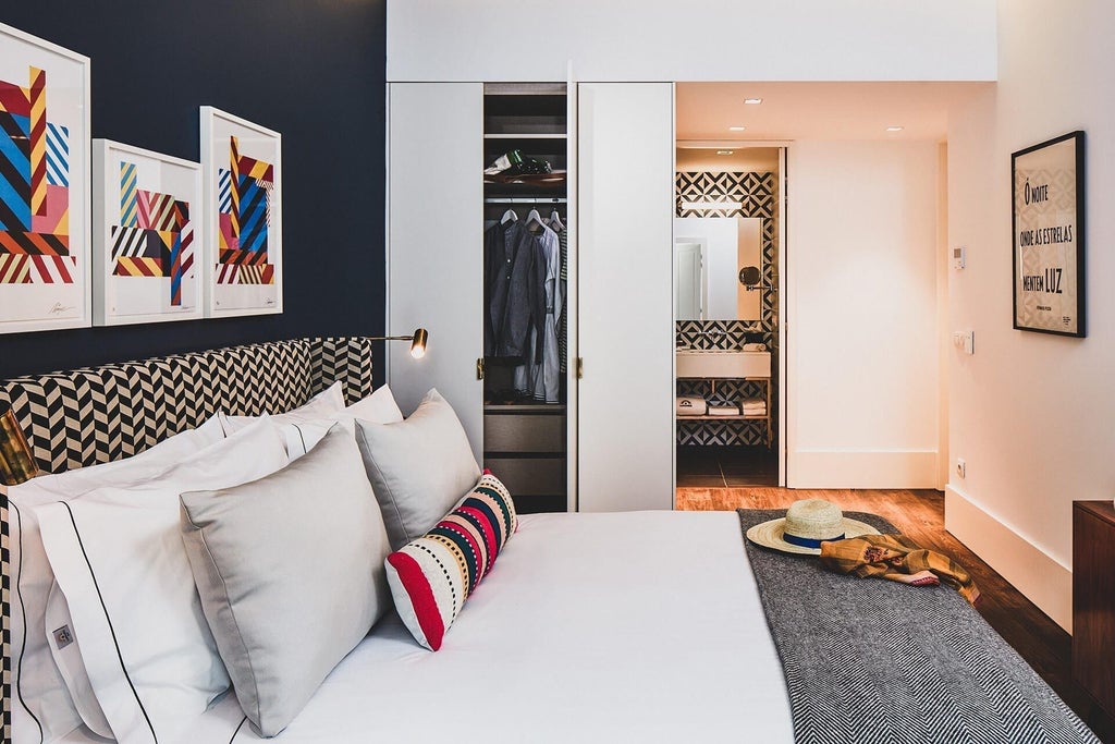 Spacious, elegant Glória Suite at The Lumiares Hotel & Spa, featuring plush white bedding, warm wooden floors, and expansive city views of Portugal's scenset landscape.