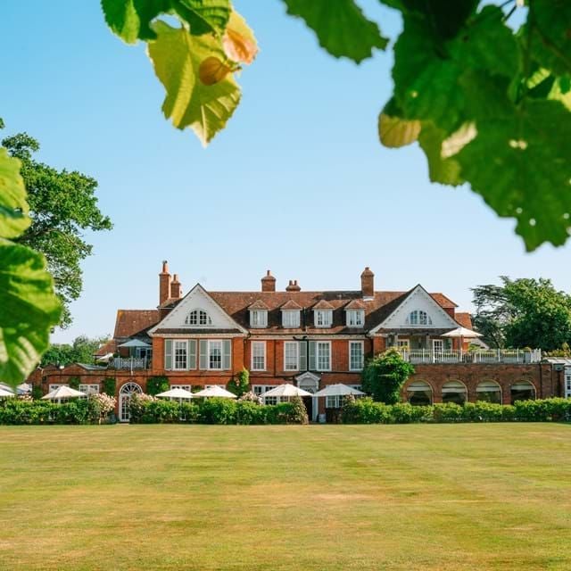 Luxurious country house hotel nestled in lush New Forest landscape, featuring elegant stone exterior, manicured gardens, and classic British architectural charm