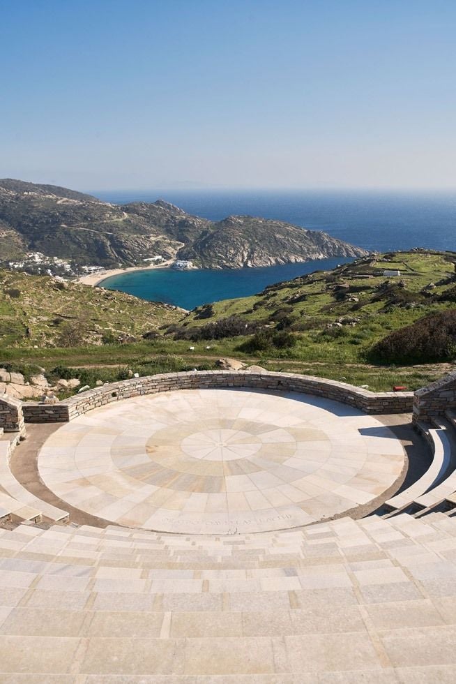 Luxurious infinity pool overlooking Aegean Sea at sunset, with white loungers and traditional Cycladic architecture in Ios, Greece