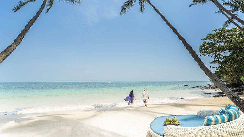 Luxurious infinity pool overlooking turquoise waters and palm-fringed coastline at Four Seasons Koh Samui resort, Thailand