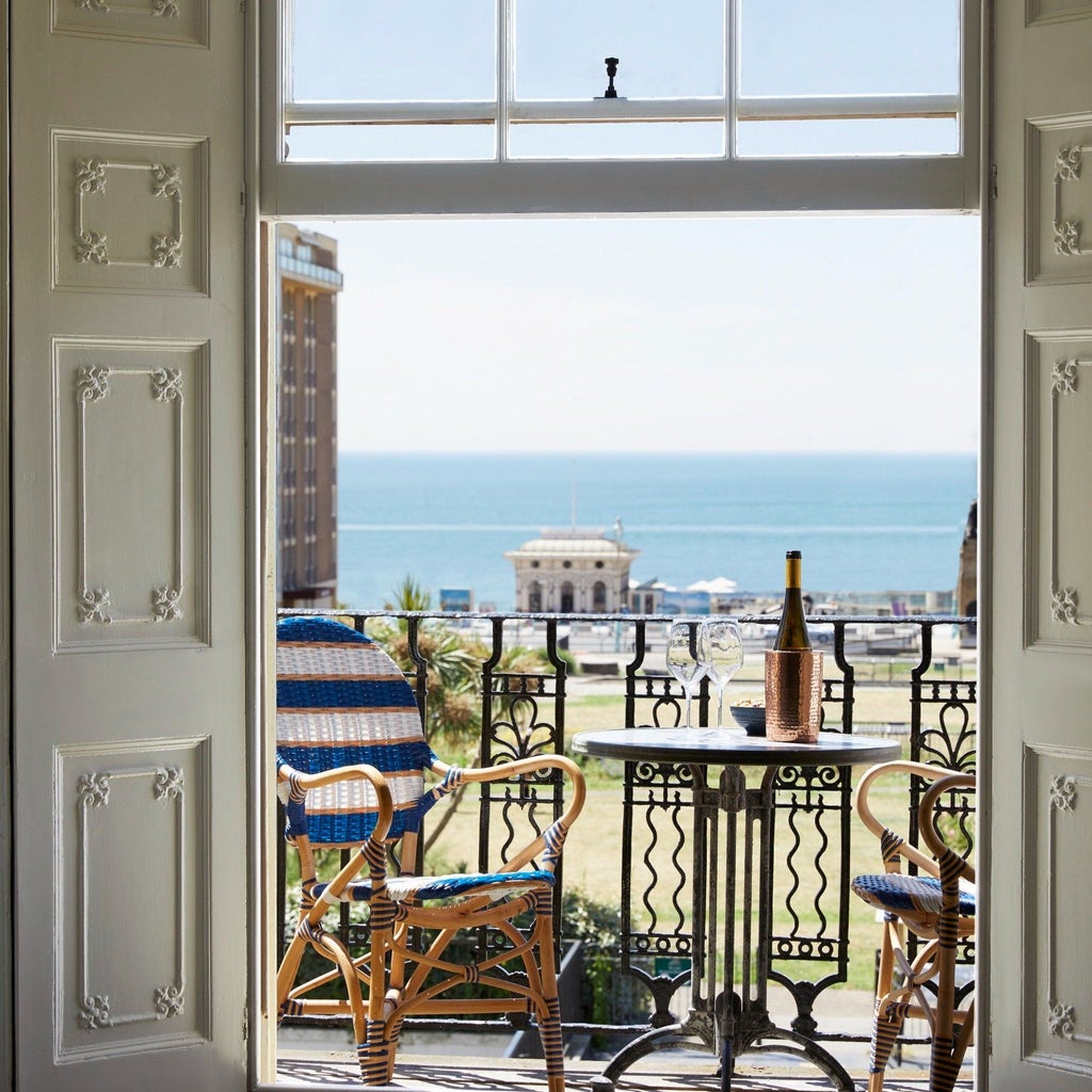 Stylish boutique hotel room with eclectic artwork, vintage furnishings, and vibrant blue walls in a historic Brighton building with coastal charm.