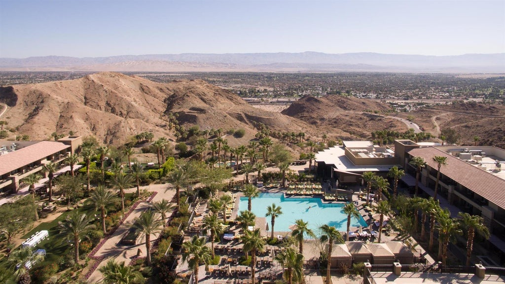 Elegant desert resort nestled in Santa Rosa Mountains, featuring infinity pools, palm trees and panoramic valley views at sunset