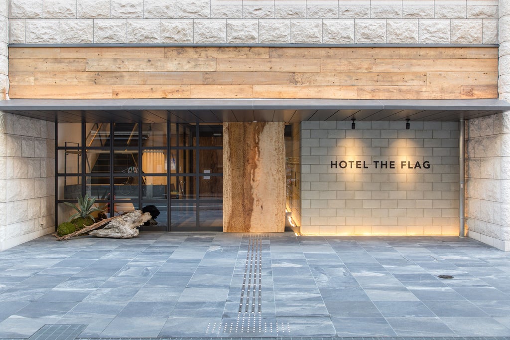 Sleek, modern hotel exterior at dusk with illuminated glass facade, vertical 