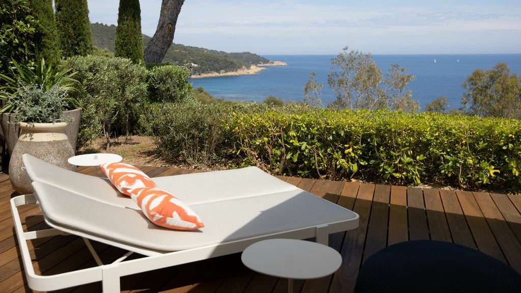 Luxurious white villa nestled on a hillside overlooking azure Mediterranean waters, surrounded by pristine gardens and minimalist contemporary architecture.