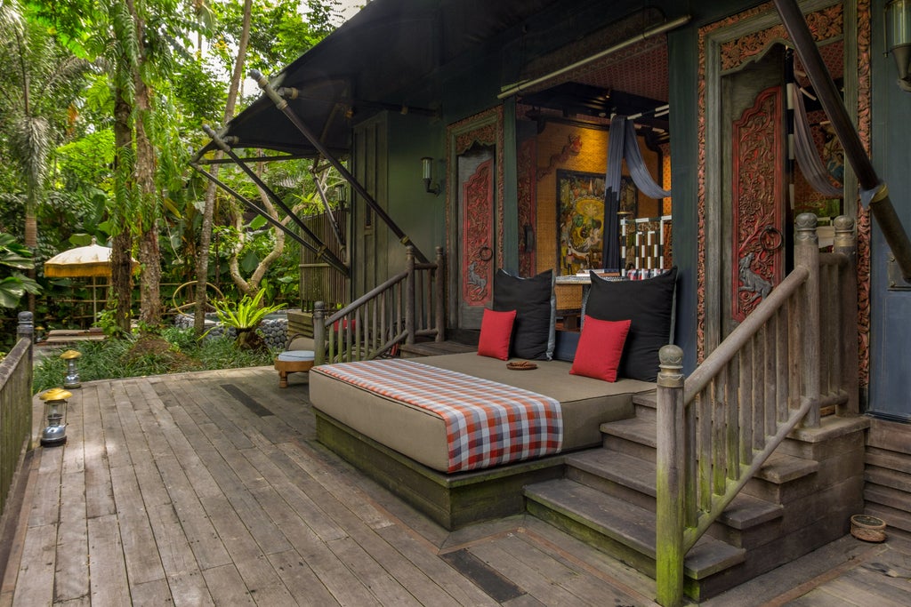 Luxurious safari-style tent suite nestled in tropical rainforest, featuring private deck, plush king bed and elegant resort furnishings