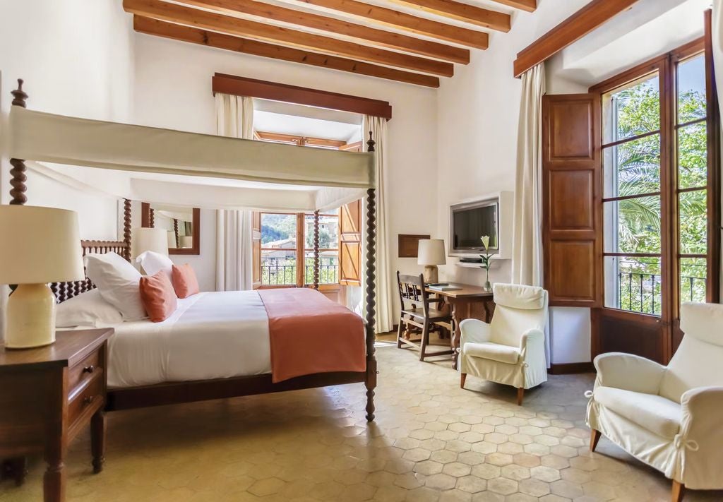 Elegant Mediterranean-styled double room with terrace views, featuring rustic wooden beams, designer furniture and luxurious white bedding