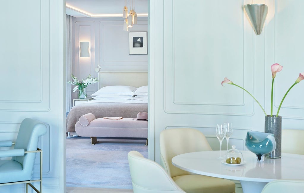 Luxurious hotel bedroom at One Aldwych with elegant white decor, plush bedding, contemporary design, and soft ambient lighting in United Kingdom.