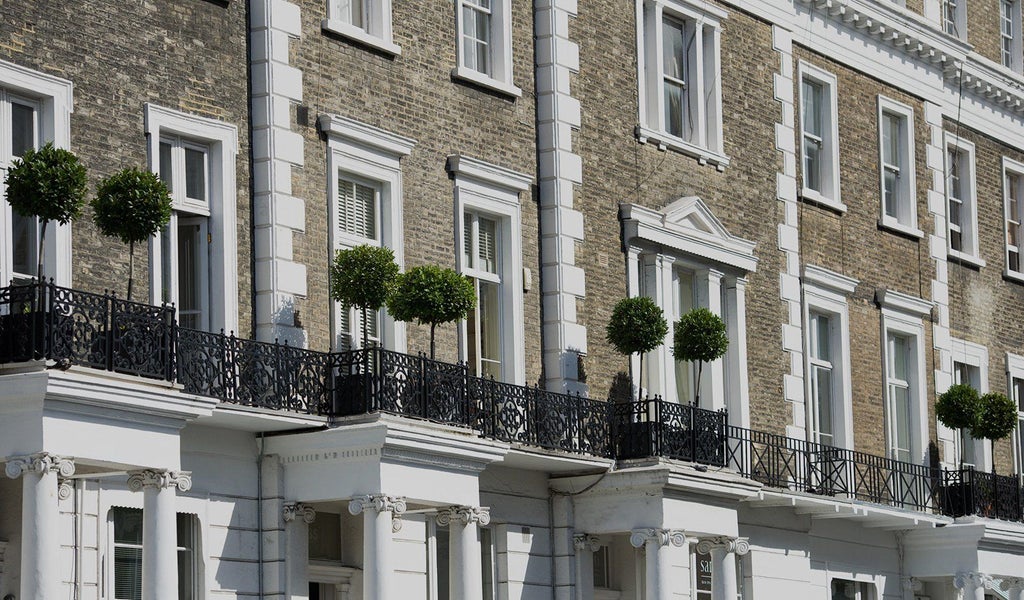 Luxurious boutique hotel facade with elegant Victorian architecture, ornate windows, and pristine white exterior in central London's vibrant neighborhood