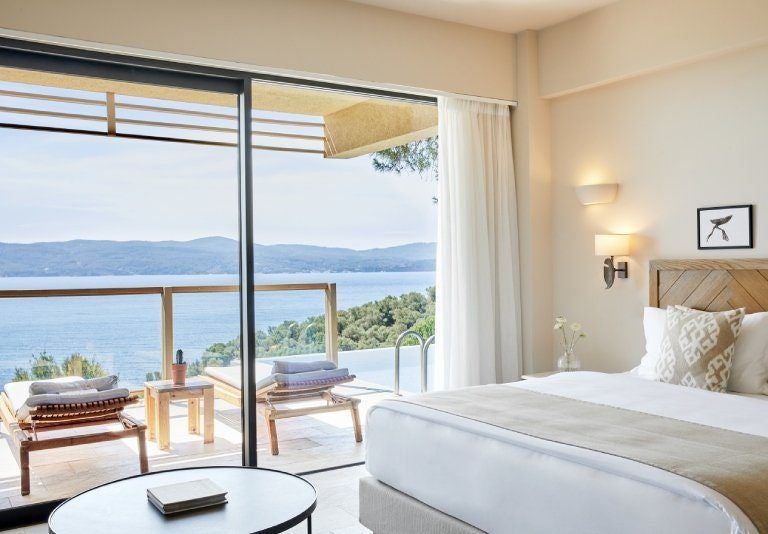 Luxurious junior suite with private pool overlooking azure Aegean waters, featuring modern minimalist decor and elegant wooden accents at ELIVI Skiathos resort