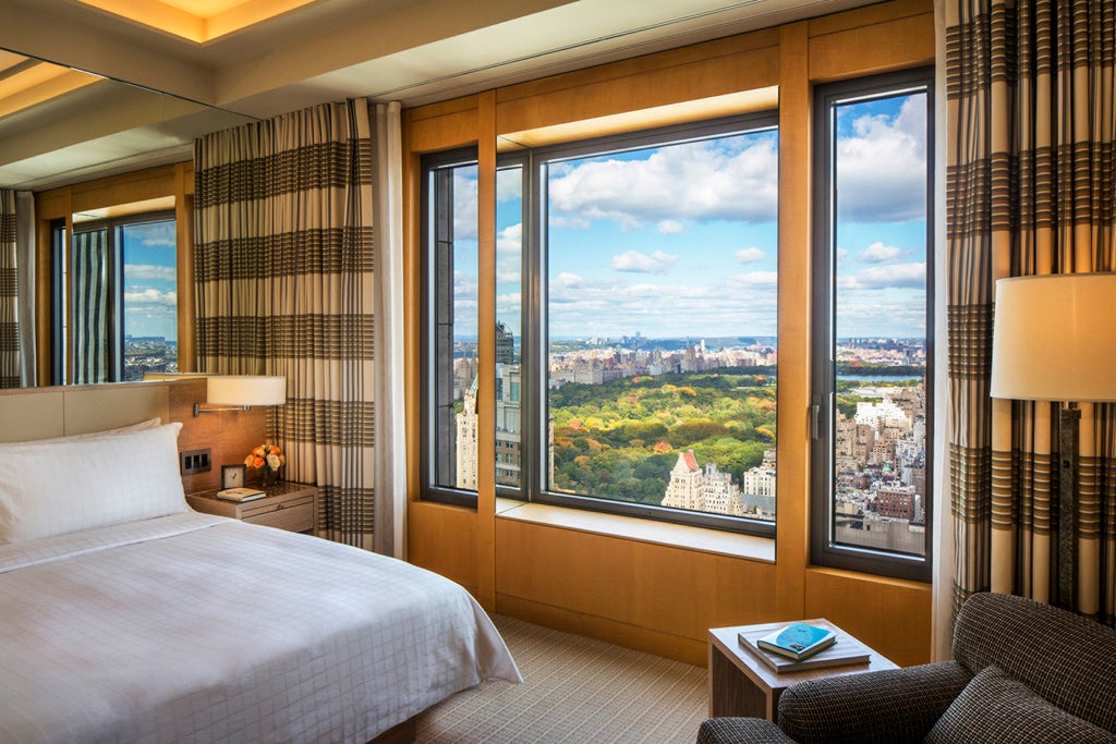 Glass-clad luxury skyscraper hotel Four Seasons soars above Manhattan skyline with classical architectural details and golden hour lighting